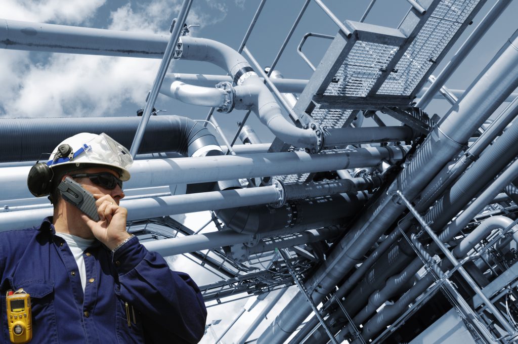 man taking a phone call in front of large mechanical system